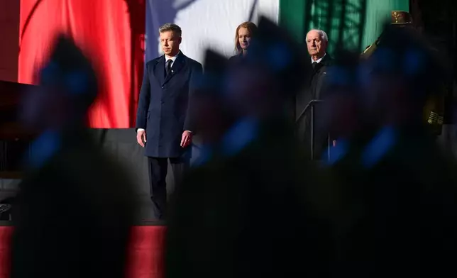 From left, Hungarian Prime Minister Peter Magyar, Agnes Forsthoffer, the Speaker of the National Assembly of Hungary and Hungary's President Andras Baka attend a flag-raising ceremony marking the 70th anniversary of the 1956 Hungarian Revolution against Soviet-backed communist rule in Budapest, Hungary, Friday, Oct. 23, 2026. (AP Photo/Pavel Bogolepov)