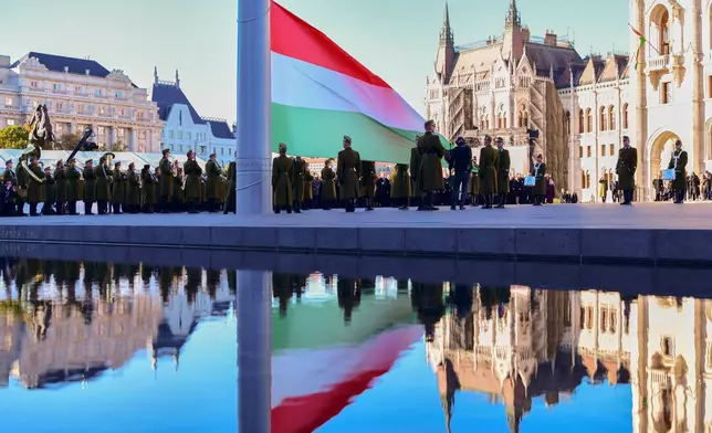 Honor guards perform a flag-raising ceremony marking the 70th anniversary of the 1956 Hungarian Revolution against Soviet-backed communist rule in Budapest, Hungary, Friday, Oct. 23, 2026. (AP Photo/Pavel Bogolepov)