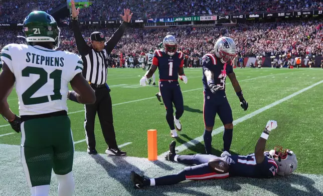 New England Patriots wide receiver Romeo Doubs, on ground, celebrates after scoring a touchdown during the first half of an NFL football game against the New York Jets in Foxborough, Mass., Sunday, Oct. 18, 2026. (AP Photo/Charles Krupa)