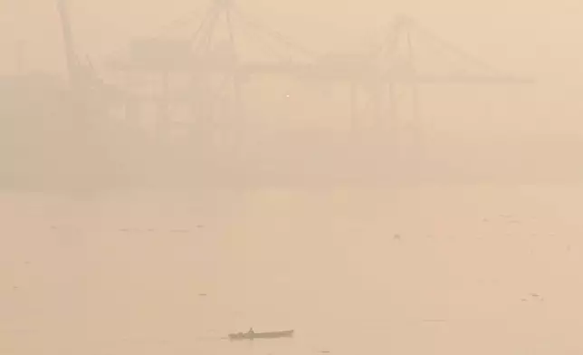 A boat cruises along the Musi River amid thick haze from forest fires in Palembang, South Sumatra, Indonesia, Thursday, Oct. 22, 2026. (AP Photo/Muhammad Hatta)