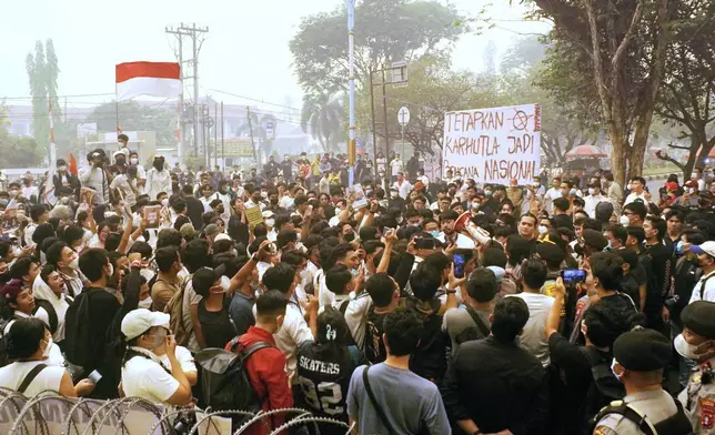 People display a poster that reads "Declare the wildfires as national disaster," during a rally protesting the Indonesian government's response to toxic haze from forest fires that has blanketed multiple cities, in Palangkaraya, Central Kalimantan, Indonesia, Friday, Oct. 23, 2026. (AP Photo/Dias Gustrian)