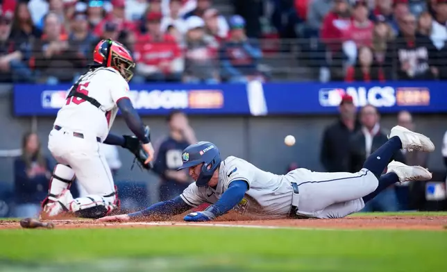 Tampa Bay Rays' Ben Williamson scores past Cleveland Guardians catcher Patrick Bailey during the second inning in Game 5 of an American League Championship Series baseball game in Cleveland, Sunday, Oct. 18, 2026. (AP Photo/David J. Phillip)