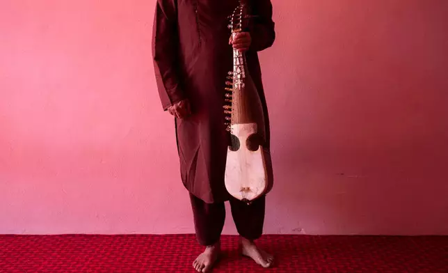 FILE - An Afghan musician poses for a portrait with his rubab in Kabul, Afghanistan, Sept. 16, 2021. (AP Photo/Bernat Armangue, File)