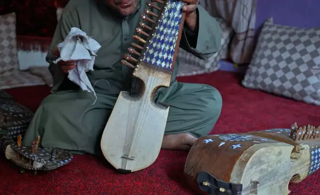 A musician who now works as a manual laborer after closing his family's instrument shop following the Taliban takeover in 2021 holds a rubab, a traditional stringed instrument, in Kabul, Afghanistan, Sunday, Oct. 11, 2026.(AP Photo/Nava Jamshidi)