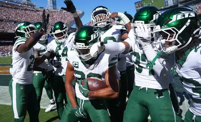 New York Jets safety Minkah Fitzpatrick holds the ball as he celebrates with teammates after intercepting a pass during the first half of an NFL football game against the Chicago Bears Sunday, Oct. 4, 2026, in Chicago. (AP Photo/David Banks)