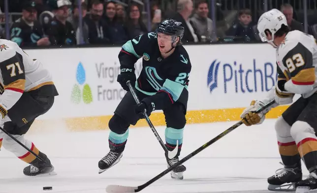 Seattle Kraken center Berkly Catton passes under pressure from Vegas Golden Knights right wing Mitch Marner (93)during the third period of an NHL hockey game, Tuesday, Oct. 6, 2026, in Seattle. (AP Photo/Lindsey Wasson)