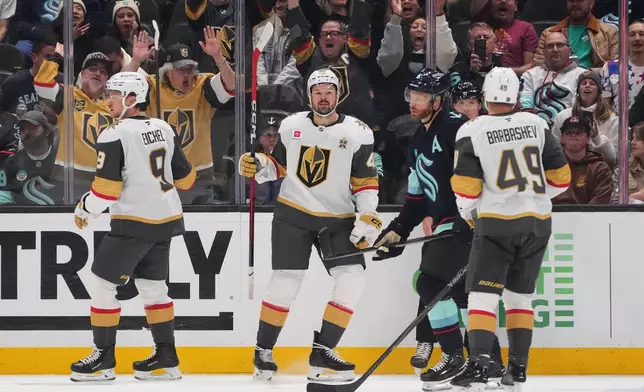 Vegas Golden Knights center Tomas Hertl, second from left, reacts with center Jack Eichel (9) and left wing Ivan Barbashev (49) after he scored a goal against the Seattle Kraken during the third period of an NHL hockey game, Tuesday, Oct. 6, 2026, in Seattle. (AP Photo/Lindsey Wasson)