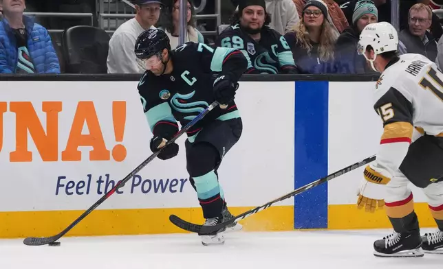 Seattle Kraken right wing Jordan Eberle moves the puck against Vegas Golden Knights defenseman Noah Hanifin (15) during the third period of an NHL hockey game, Tuesday, Oct. 6, 2026, in Seattle. (AP Photo/Lindsey Wasson)