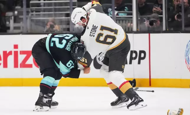 Seattle Kraken defenseman Brandon Montour (62) fights with Vegas Golden Knights right wing Mark Stone (61) during the third period of an NHL hockey game, Tuesday, Oct. 6, 2026, in Seattle. (AP Photo/Lindsey Wasson)