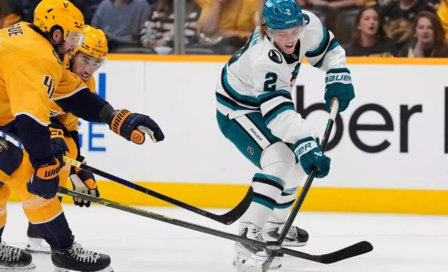 San Jose Sharks center Will Smith (2) shoots the puck past Nashville Predators defensemen Nicolas Hague (41) and Adam Wilsby (2) during the first period of an NHL hockey game Thursday, Oct. 15, 2026, in Nashville, Tenn. (AP Photo/George Walker IV)