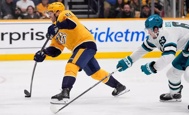 Nashville Predators center Jonathan Marchessault (81) shoots the puck past San Jose Sharks center Zack Ostapchuk (63) during the second period of an NHL hockey game Thursday, Oct. 15, 2026, in Nashville, Tenn. (AP Photo/George Walker IV)