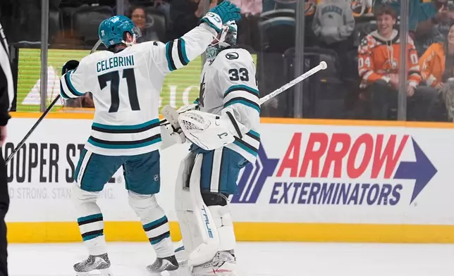 San Jose Sharks center Macklin Celebrini (71) congratulates goaltender Alex Nedeljkovic (33) after the team's shootout win in an NHL hockey game against the Nashville Predators, Thursday, Oct. 15, 2026, in Nashville, Tenn. (AP Photo/George Walker IV)
