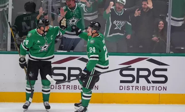 Dallas Stars center Roope Hintz (24) celebrates after scoring an overtime goal with teammate Jamie Benn, left, during an NHL hockey game against the Winnipeg Jets, Thursday, Oct. 22, 2026, in Dallas. (AP Photo/LM Otero)