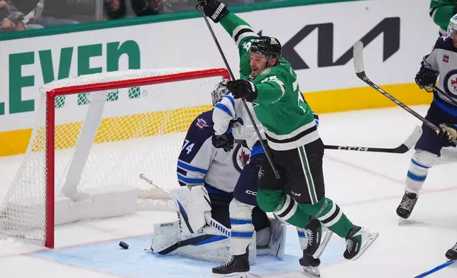 Dallas Stars center Roope Hintz (24) jumps after scoring a goal against Winnipeg Jets goaltender Stuart Skinner (74) during the third period of an NHL hockey game Thursday, Oct. 22, 2026, in Dallas. (AP Photo/LM Otero)