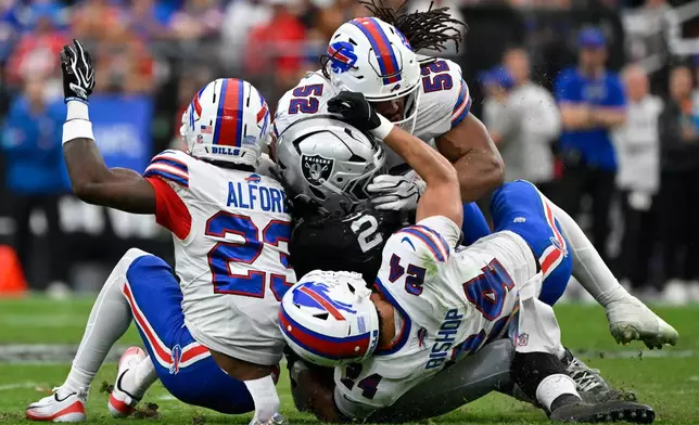 Las Vegas Raiders running back Ashton Jeanty (2) is stopped by Buffalo Bills linebacker Kaleb Elarms-Orr (52), cornerback Dee Alford (23) and safety Cole Bishop (24) during an NFL football game in Las Vegas, Sunday, Oct. 18, 2026. (AP Photo/David Becker)