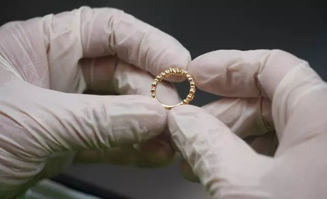 A craftsperson holds up a ring for inspection at the Pandora factory in Ho Chi Minh city, Vietnam, Wednesday, Sept.30, 2026. (AP Photo/Hau Dinh)