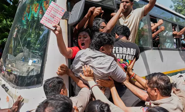 Socialist, left-wing parties and student activists shout slogans from a police vehicle after being detained during a protest against Chief Election Commissioner Gyanesh Kumar and calling for the suspension of the Special Intensive Revision (SIR) of electoral rolls in New Delhi, India, Friday, Oct. 2, 2026. (AP Photo/Manish Swarup)