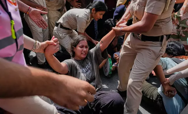 Socialist, left-wing parties and student activists shout slogans as police detain them during a protest against Chief Election Commissioner Gyanesh Kumar and calling for the suspension of the Special Intensive Revision (SIR) of electoral rolls in New Delhi, India, Friday, Oct. 2, 2026. (AP Photo/Manish Swarup)