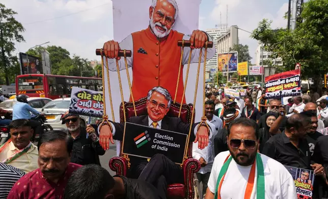 Supporters of India's opposition Congress party hold a poster featuring Indian Prime Minister Narendra Modi, top and Chief Election Commissioner Gyanesh Kumar, bottom, during a protest against Kumar, the Special Intensive Revision (SIR) of electoral rolls, and the alleged the exclusion of millions of voters from draft electoral rolls, in Ahmedabad, India, Tuesday, Sept. 29, 2026. (AP Photo/Ajit Solanki)