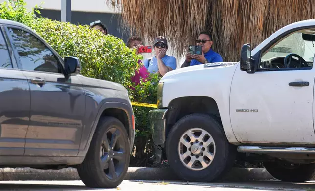 People watch as Harris County Sheriff deputies work the scene near two vehicles involved after a man was struck by an ICE agent's vehicle during an immigration enforcement operation in northwest Houston, Saturday, Oct. 10, 2026. 9Jason Fochtman/Houston Chronicle via AP)