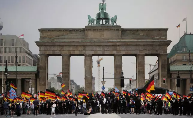 FILE - AfD supporters wave AfD flags and German national flags during a demonstration in front of the Brandenburg Gate in Berlin, Germany, May 27, 2018. (AP Photo/Markus Schreiber, File)