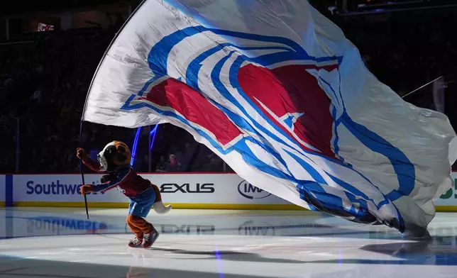 Colorado Avalanche mascot Bernie the St. Bernard carries the team flag before an NHL hockey game against the Tampa Bay Lightning, Friday, Oct. 23, 2026, in Denver. (AP Photo/David Zalubowski)