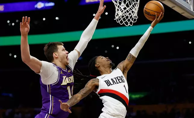 Portland Trail Blazers guard Ja Morant (1) drives to the basket as Los Angeles Lakers center Walker Kessler, left, defends during the first half of an NBA basketball game Tuesday, Oct. 27, 2026, in Los Angeles. (AP Photo/Caroline Brehman)
