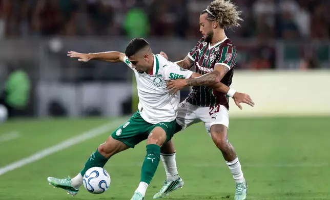 Andreas Pereira of Brazil's Palmeiras, left, is challenged by Guga of Brazil's Fluminense during the first leg of a Copa Libertadores semifinal soccer match in Rio de Janeiro, Wednesday, Oct. 14, 2026. (AP Photo/Bruna Prado)