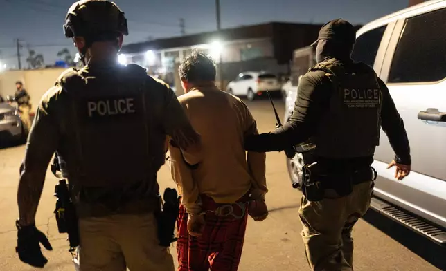 Homeland Security Investigations task force officers escort a suspect accused of illegally registering to vote during a federal operation in Commerce, Calif., Monday, Oct. 19, 2026. (AP Photo/Jae C. Hong)