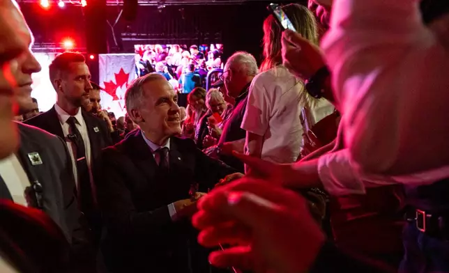 Canada's Prime Minister Mark Carney, center, greets people at a Forever Canadian rally in Edmonton, on Friday, Oct. 16, 2026. (John Ulan/The Canadian Press via AP)