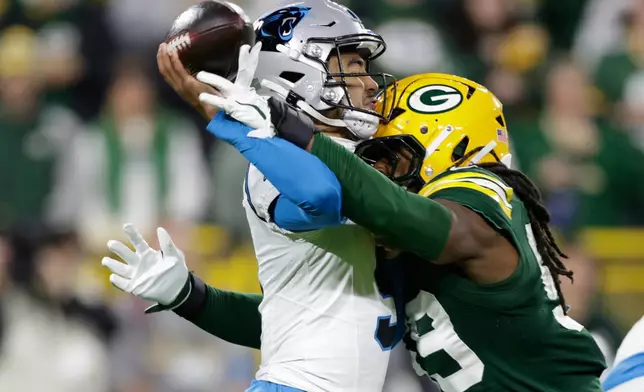 Carolina Panthers quarterback Bryce Young, left, is hit by Green Bay Packers linebacker Ty'ron Hopper, right as he throws a pass during the first half of an NFL football game in Green Bay, Wis., Thursday, Oct. 29, 2026. (AP Photo/Matt Ludtke)