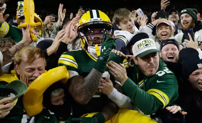 Green Bay Packers wide receiver Matthew Golden leaps into the stands as he celebrates scoring a touchdown during the first half of an NFL football game against the Carolina Panthersin Green Bay, Wis., Thursday, Oct. 29, 2026. (AP Photo/Mike Roemer)