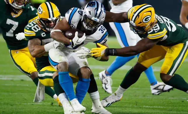 Carolina Panthers running back Chuba Hubbard (30) is tackled by Green Bay Packers linebacker Isaiah McDuffie (58) and defensive end Barryn Sorrell (99) during the first half of an NFL football game in Green Bay, Wis., Thursday, Oct. 29, 2026. (AP Photo/Mike Roemer)