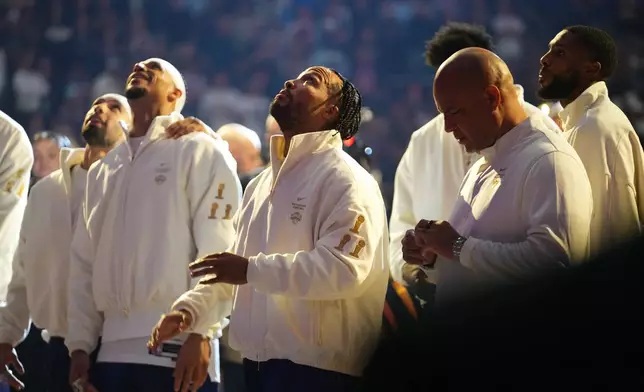 New York Knicks guard Jalen Brunson, looks on with teammates as the Knicks 2025-26 World Champions banner is raised before an NBA basketball game between the New York Knicks and the Philadelphia 76ers Tuesday, Oct. 20, 2026, in New York. (AP Photo/Frank Franklin II)