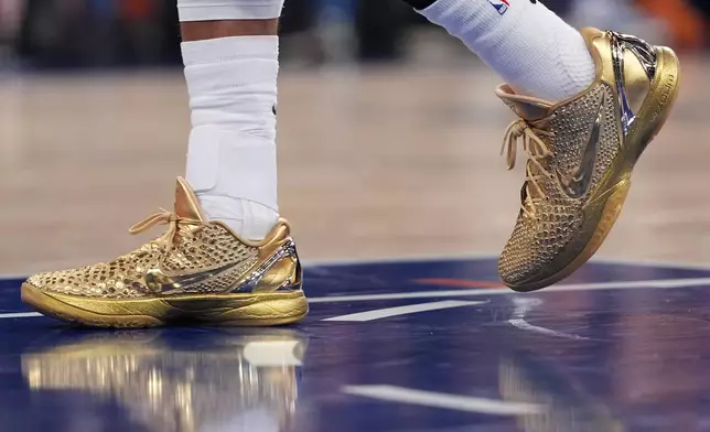 New York Knicks guard Jalen Brunson wears gold colored shoes during the second half of an NBA basketball game against the Philadelphia 76ers Tuesday, Oct. 20, 2026, in New York. (AP Photo/Frank Franklin II)