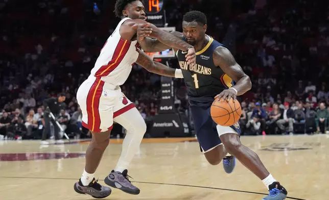 Miami Heat guard Davion Mitchell defends New Orleans Pelicans forward Zion Williamson (1) during the first half of an NBA preseason basketball game Thursday, Oct. 8, 2026, in Miami. (AP Photo/Marta Lavandier)