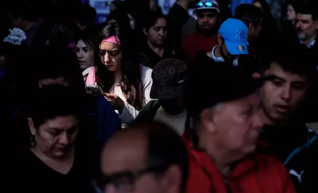 People line up at a job fair where companies are offering employment opportunities at the Central train station in Santiago, Chile, Thursday, Oct. 15, 2026. (AP Photo/Esteban Felix)