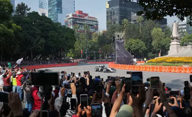 Mexican driver Sergio Perez of the Cadillac F1 Team drives along Paseo de la Reforma during an exhibition in Mexico City, Wednesday, Oct. 28, 2026. (AP Photo/Eduarto Verdugo)