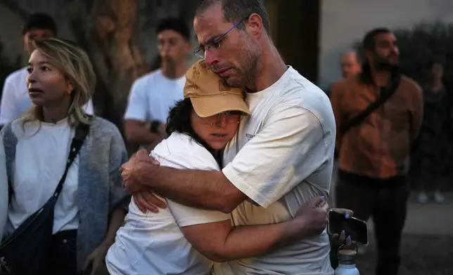 People attend a memorial service marking the third anniversary of the Oct. 7, 2023, Hamas cross-border attack on Israel, in Kibbutz Kfar Aza, southern Israel, where many community members were killed and abducted, Wednesday, Oct. 7, 2026. (AP Photo/Ariel Schalit)