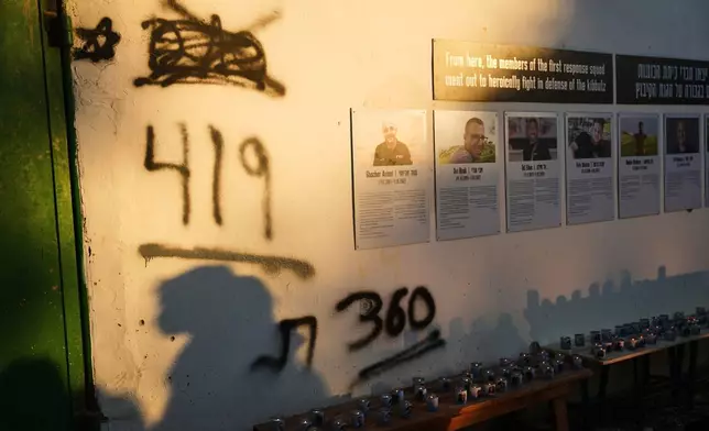 Shadows stretch across a memorial wall as Israel marks the third anniversary of the Oct. 7, 2023, Hamas cross-border attack in Kibbutz Kfar Aza, southern Israel, where many community members were killed and abducted, Wednesday, Oct. 7, 2026. (AP Photo/Ariel Schalit)