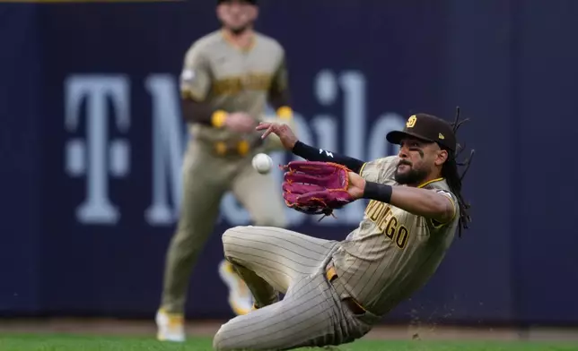 San Diego Padres' Fernando Tatis Jr. makes a sliding catch on a ball hit by Milwaukee Brewers' Jackson Chourio during the fourth inning of Game 2 of a National League Divisional baseball playoff series Sunday, Oct. 4, 2026, in Milwaukee. (AP Photo/Kayla Wolf)