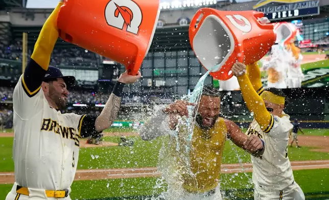Milwaukee Brewers' Jackson Chourio is douced by Garrett Mitchell and William Contreras after hitting a walkoff hit during the ninth inning of Game 2 of a National League Divisional baseball playoff series against the San Diego Padres Sunday, Oct. 4, 2026, in Milwaukee. (AP Photo/Kayla Wolf)