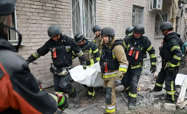 Rescue workers carry a body after pulling from the rubble of a residential building destroyed by a Russian airstrike in Zaporizhzhia, Ukraine, Saturday, Oct. 10, 2026. (AP Photo/Kateryna Klochko)