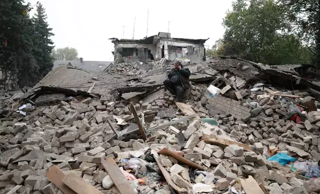 A man talks on the phone while sitting on the rubble of a residential building destroyed by a Russian airstrike in Zaporizhzhia, Ukraine, Saturday, Oct. 10, 2026. (AP Photo/Kateryna Klochko)