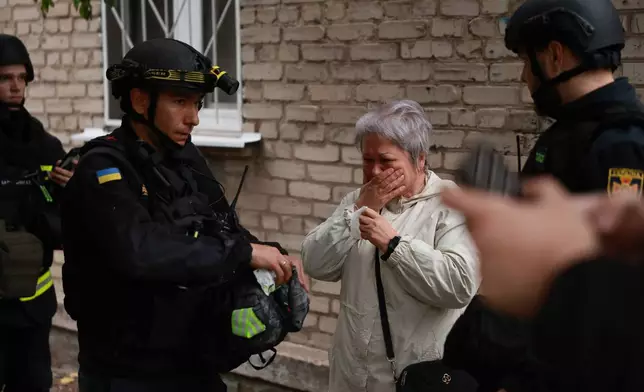 A woman reacts after pulling her relatives from the rubble of a residential building destroyed by a Russian airstrike in Zaporizhzhia, Ukraine, Saturday, Oct. 10, 2026. (AP Photo/Kateryna Klochko)