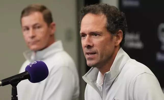 Walker Monfort, back, president of the Colorado Rockies, listens as Paul DePodesta, president of baseball operations for the Colorado Rockies, responds to question during an end-of-season press conference Tuesday, Oct. 6, 2026, in Coors Field in Denver. (AP Photo/David Zalubowski)