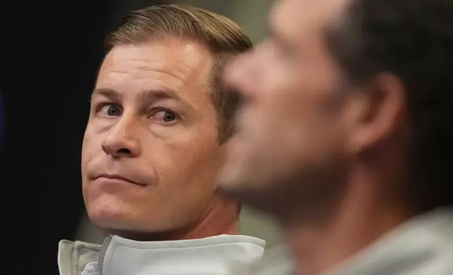 Walker Monfort, back, president of the Colorado Rockies, listens as Paul DePodesta, president of baseball operations for the Colorado Rockies, while responding to a question during an end-of-season press conference Tuesday, Oct. 6, 2026, in Coors Field in Denver. (AP Photo/David Zalubowski)