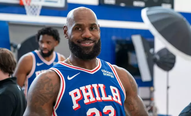 Philadelphia 76ers' LeBron James reacts as he goes between stations during the NBA basketball team's media day, Monday, Sept. 28, 2026, in Camden, N.J.. (AP Photo/Chris Szagola)