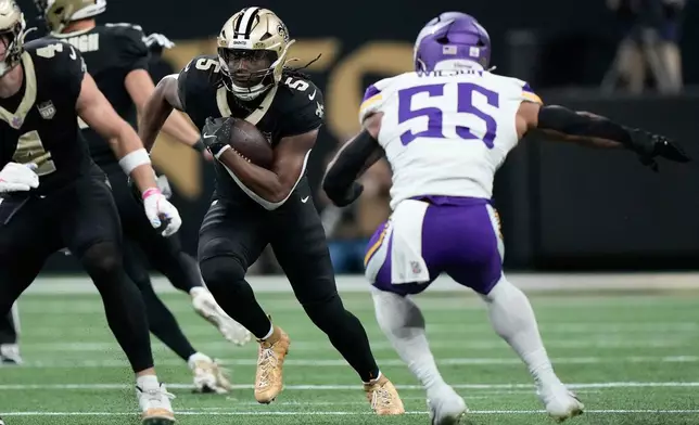 New Orleans Saints running back Kendre Miller (5) runs against Minnesota Vikings linebacker Eric Wilson (55) during the first half of an NFL football game in New Orleans, Sunday, Oct. 11, 2026. (AP Photo/Gerald Herbert)