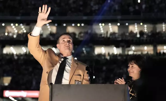 Former New Orleans Saints quarterback Drew Brees, left, gestures next to Saints owner & CEO Gayle Benson while being inducted into the team's Ring of Honor during halftime of an NFL football game between the Saints and the Minnesota Vikings in New Orleans, Sunday, Oct. 11, 2026. (AP Photo/Matthew Hinton)